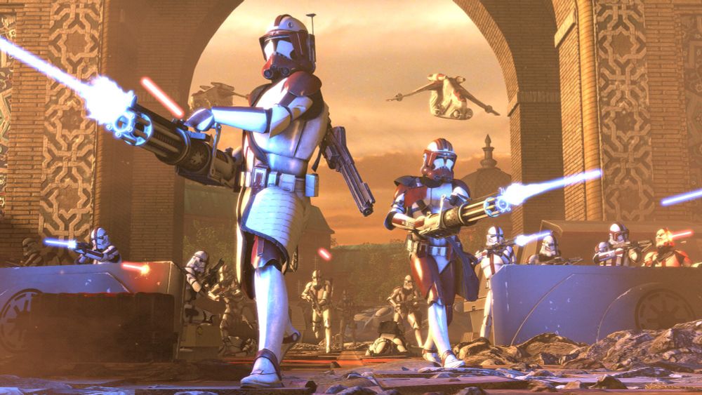 Two heavy clone troopers advance through a city street firing Z-6 rotary cannons. More clones run up to cover behind them, and two LAATs fly through the sky.