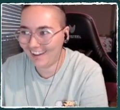 Un screen un peu flou de moi, avec une expression contente sur le visage, un grand sourire. 
Je porte les cheveux attachés et un t-shirt vert pâle.