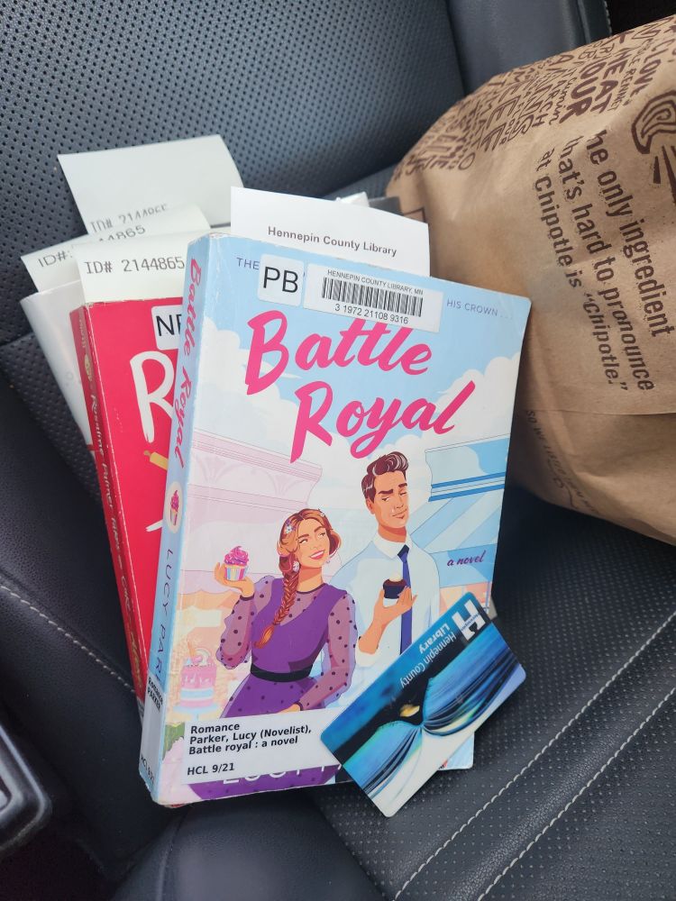 A stack of library books with a Hennepin County library card on top