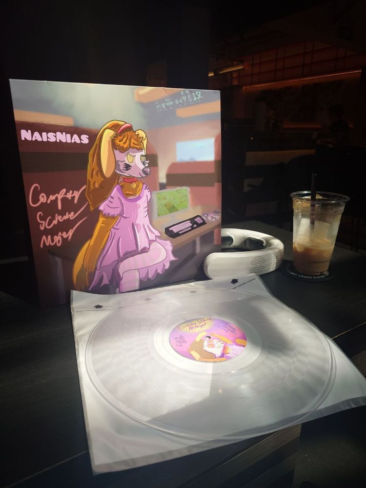The vinyl EP of Computer Science Major, showcasing the transparent vinyl out. Alongside the vinyl is a neck cooler and an iced chocolate drink
