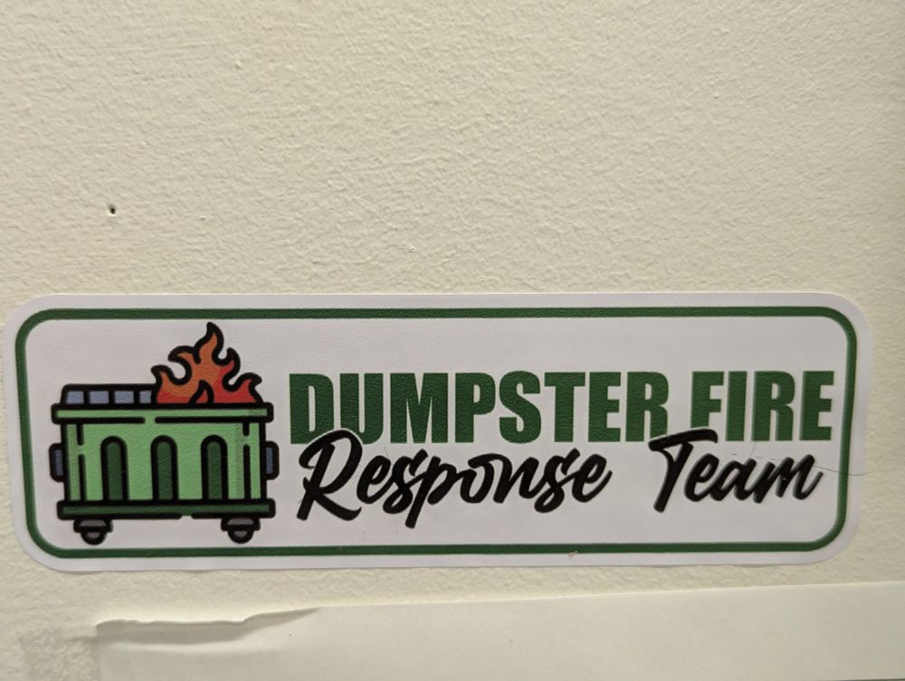 Bumper sticker that shows a green dumpster on fire with the words 'Dumpster Fire Response Team' on it.