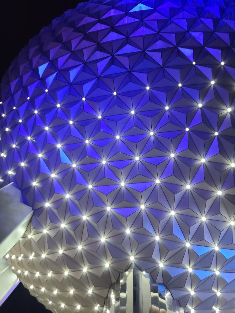 A night time photo of Spaceship Earth at Epcot, Walt Disney World in Florida. It is a large  polyhedron shaped like a sphere and has a regular pattern of lights