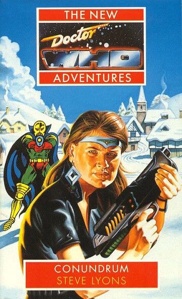 Ace, dressed in a short sleeved black top and wearing a metallic circlet and diamond shaped earrings, is half turned toward the viewer and holding a space gun. Behind her, in front of an idyllic snow covered village, a costumed cartoon supervillain (big yellow boots, green Lycra, red pants and gloves, a golden mask and big blue cape) aims a gun at her. Cover of Conundrum by Steve Lyons
