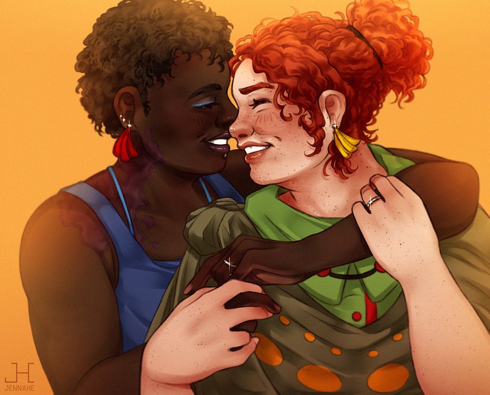 Portrait of a couple, they're smiling and holding each other. Warm yellow light is casting on top of both women.