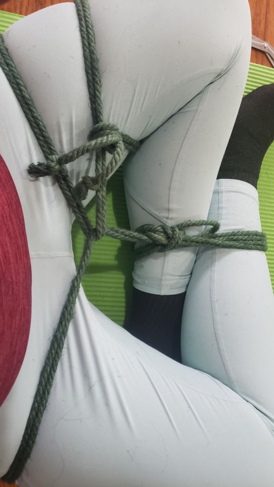 Delia with her legs tied forcing her to sit cross legged