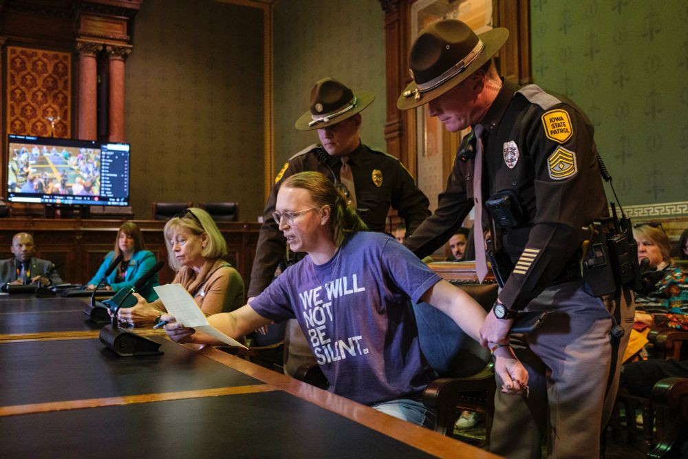 Iowa State Troopers remove Chris Morse of Polk County from the room after Morse exceeded her allotted time while speaking in opposition to House Study Bill 242 during an Iowa House Judiciary Subcommittee meeting at the Iowa State Capitol in Des Moines, Iowa on Monday, February 24, 2025. The bill would remove gender identity as a protected class under Iowa’s Civil Rights Act.