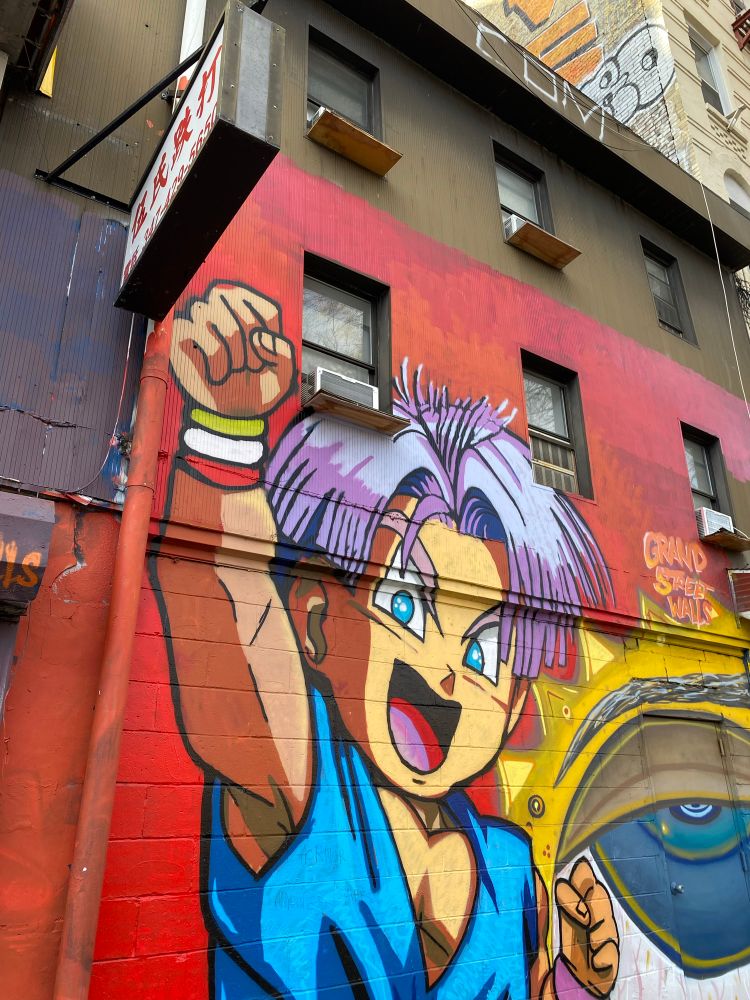 Urban art of the manga/anime character “Trunks,” from the Dragon Ball series, with his purple hair and one fist raised in the air. 