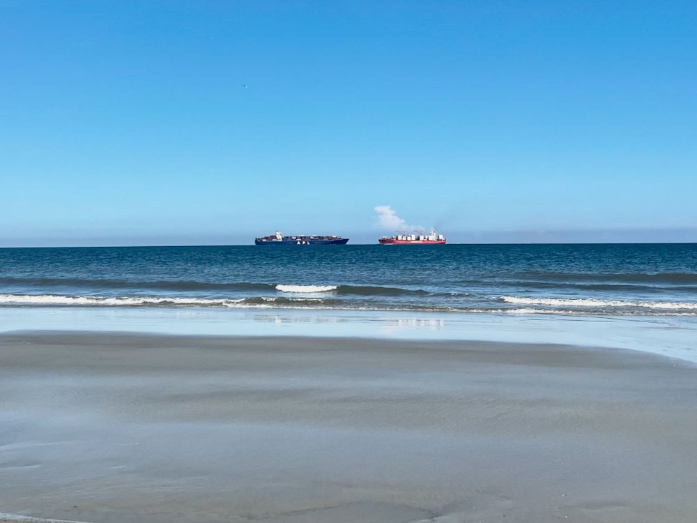 A photograph of container ships APL Oregon (left) and Polar Mexico (right) passing each other near the mouth of the Savannah River as seen from Tybee Island, Georgia.