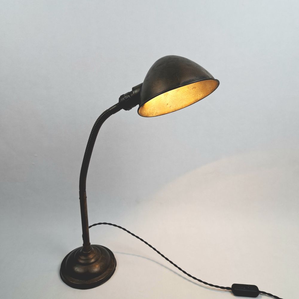 Antieke metalen bureaulamp met een 'gooseneck', een nek die buigt.