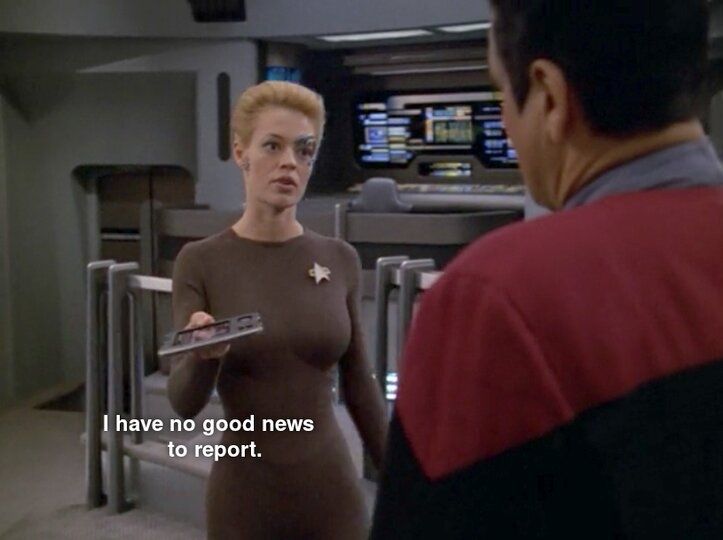 Star Trek Voyager scene. We're on the bridge and see Seven of Nine (Tertiary adjunct of Unimatrix -01) standing and handing a PADD to Chakotay. Chakotay is in red uniform, Seven is in her 'not yet ready for prime time Starfleet officer' bodysuit thing. Closed caption reads, "I have no  good news to report."