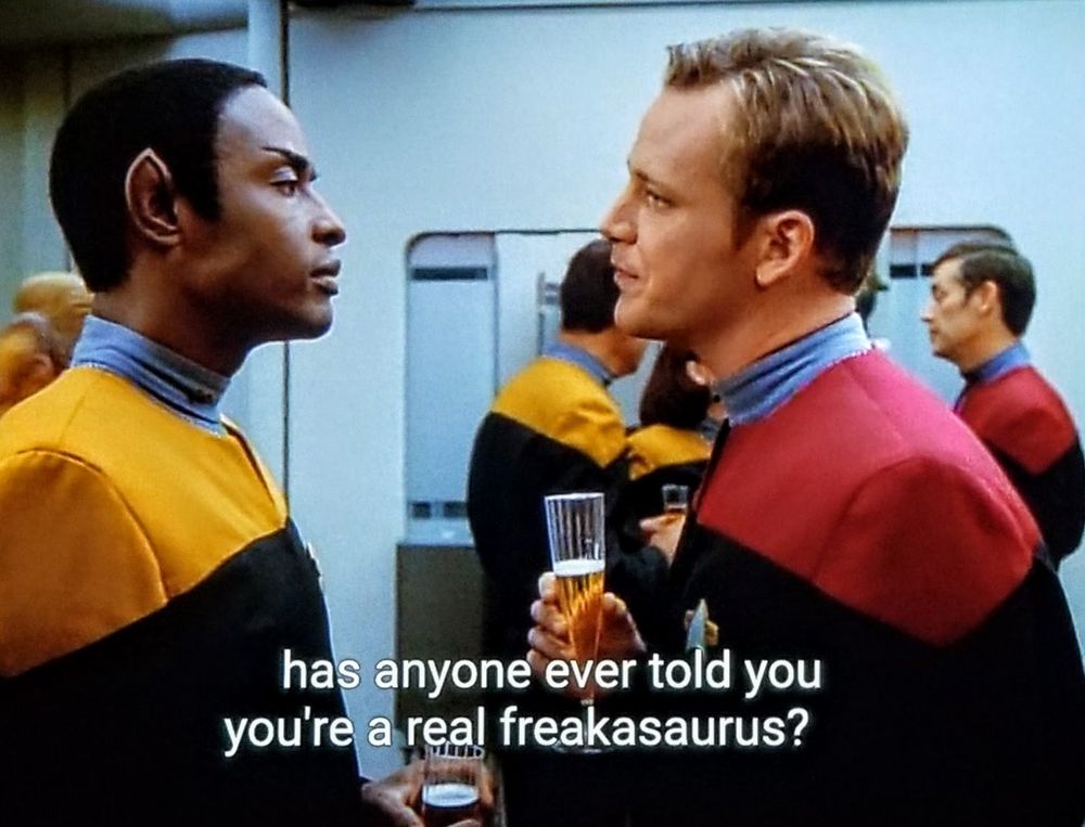 Star Trek Voyager scene. We're at a fancy party in the dining hall on Voyager. Folks are mingling. (In uniform tho it's not a jeans day) Front and center, Tuvok is talking with Paris. They both have a 'come at me, bro' look at each other but I think it's lighthearted. Paris is holding a champagne glass. Closed caption reads, 