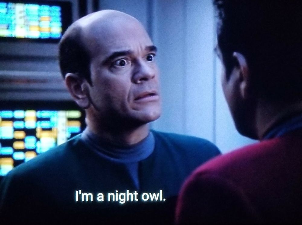 Star Trek Voyager scene. We see the EMH Doctor looking shooketh AF talking to Chakotay like Chakotay just told him he's maybe gonna have a romantic storyline with Seven a few seasons from now. Closed caption reads, "I'm a night owl."