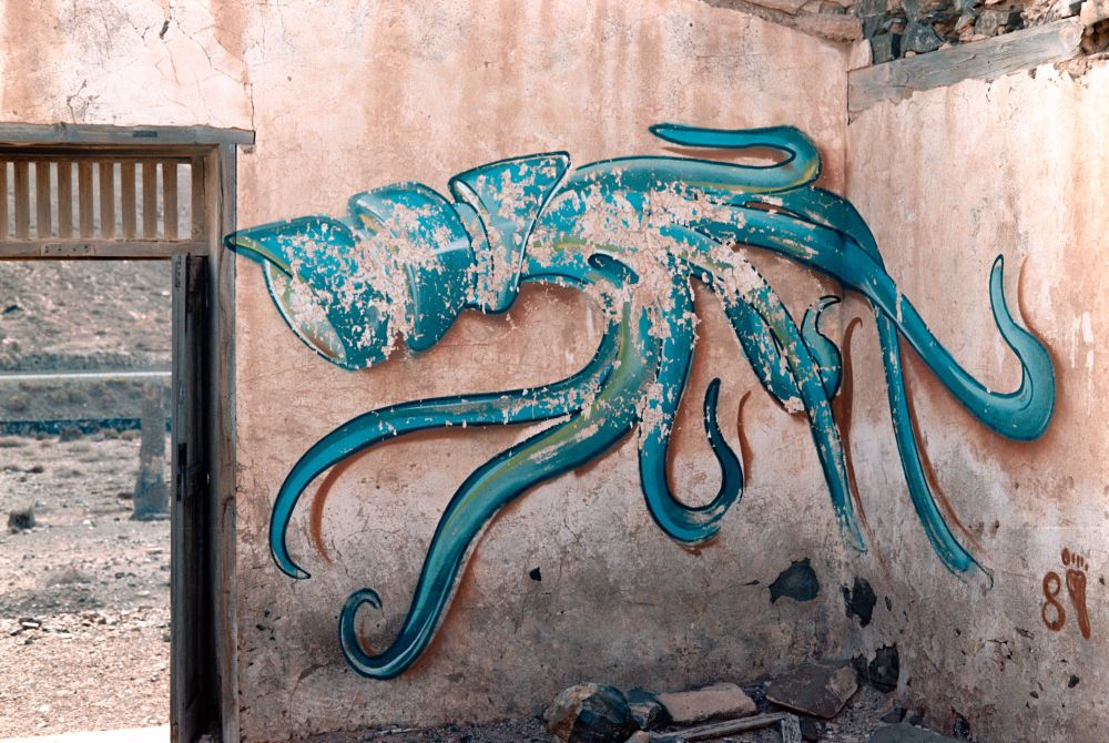 Interior of an abandoned building with a graffiti painting of a squid