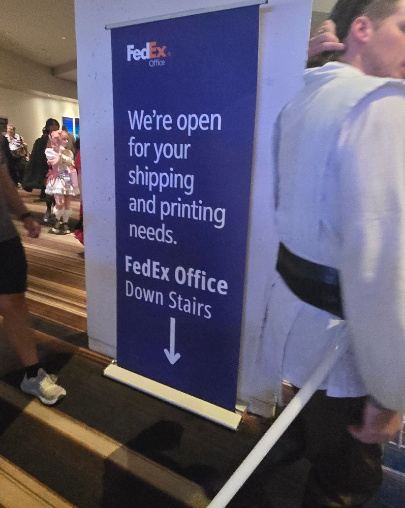 A large FedEx banner in the Marriott that says, "we're open for your printing and shipping needs. FedEx office downstairs"