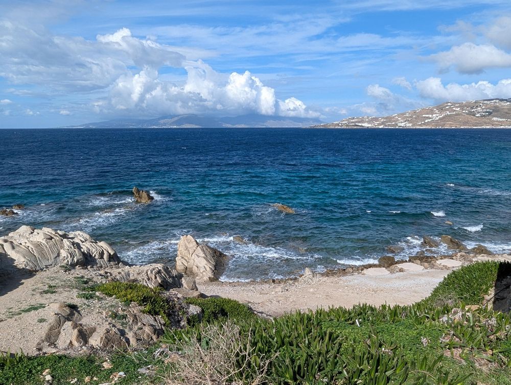 Partly cloudy sky over the deep blue waters of Mykonos