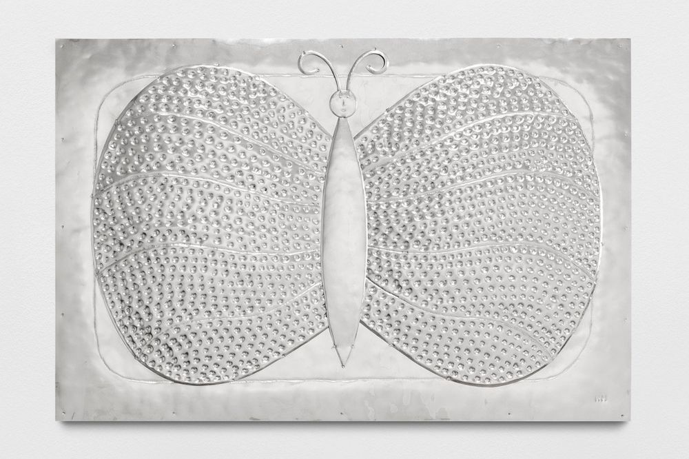 Photo of a sheet of hammered stainless steel into an image of a butterfly