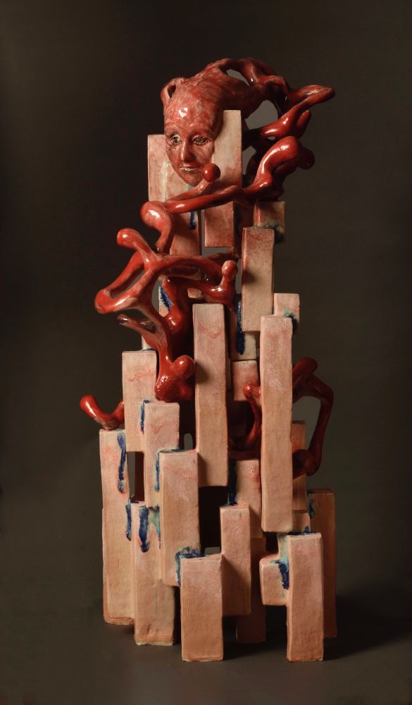 Red glazed ceramic of some blocks and a face at the top