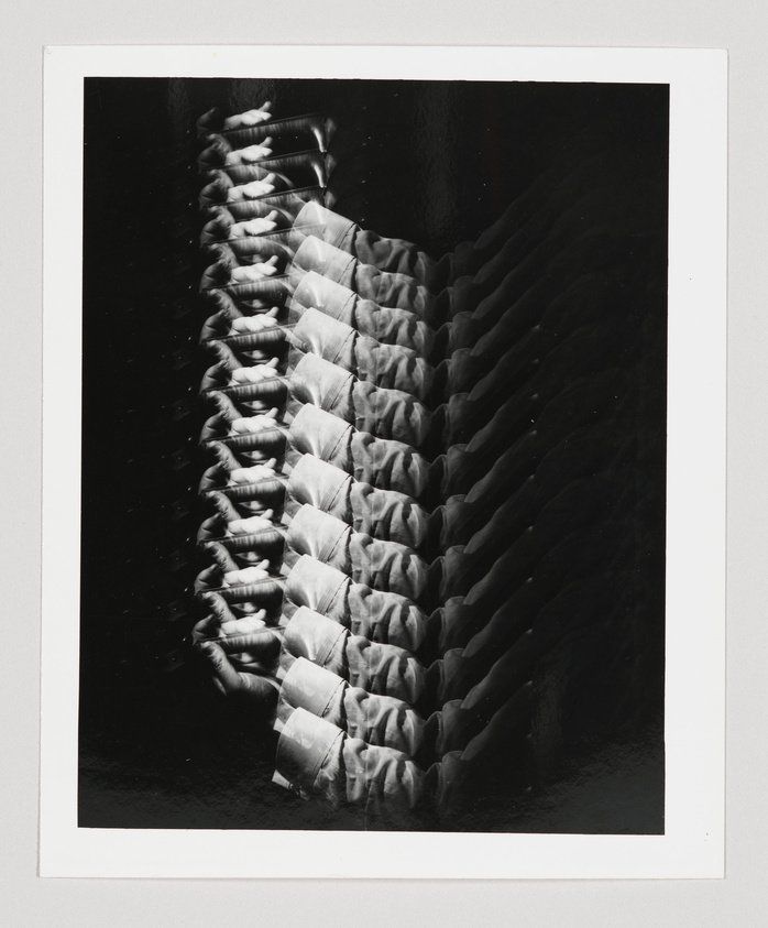 Black and white silver print of a repeated image of a man’s arm holding a violin
