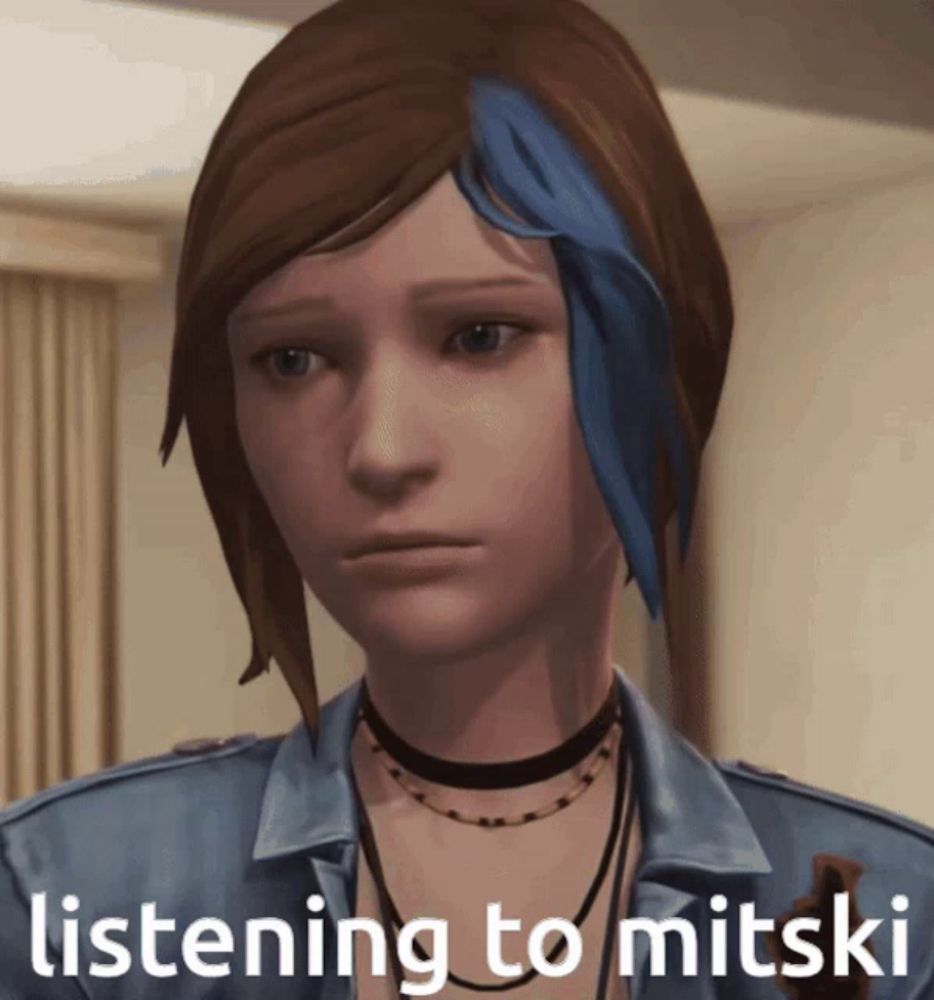 a video game character with blue hair is listening to mitski