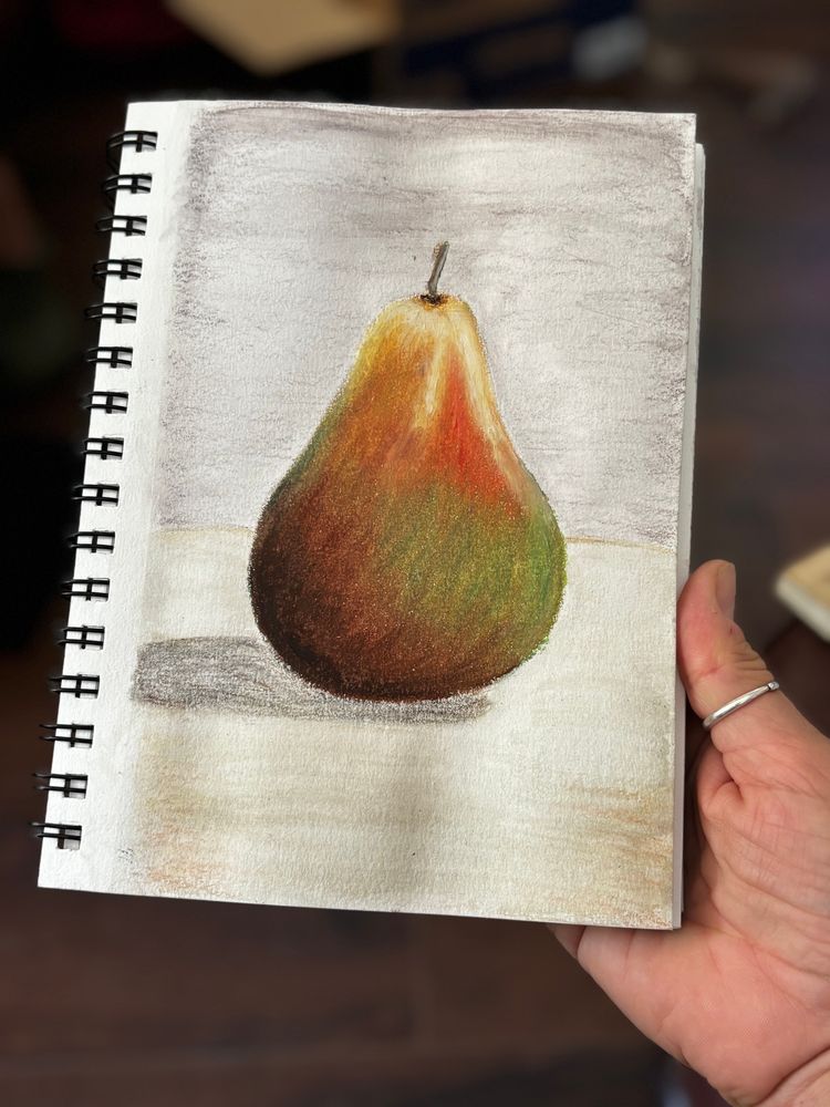 A still life drawing of a pear in oil pastel. 