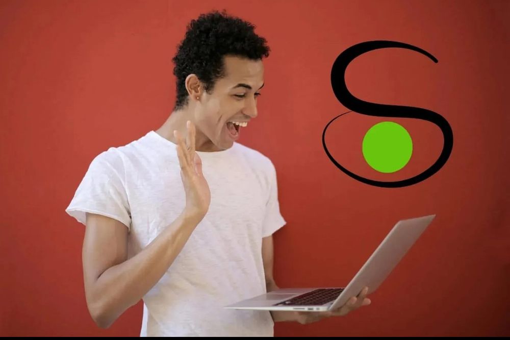 A young person wearing a white t-shirt holds a laptop and looks at it excitedly. The Saners’ logo is displayed above the laptop.