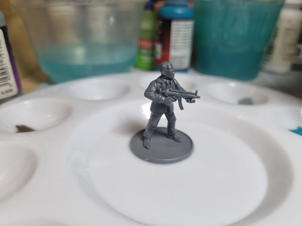 A plastic miniature of a man in a suit holding an MP5 submachinegun