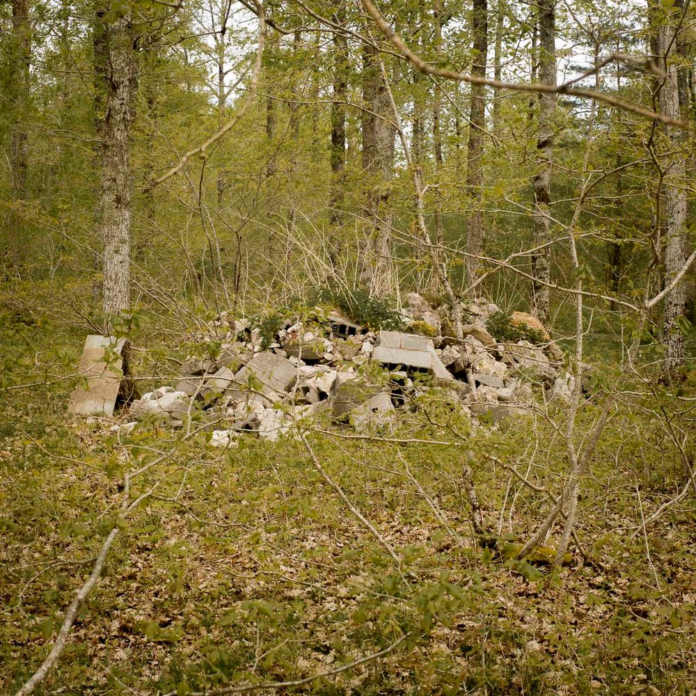 Un tas de parpaings et de gravats au beau milieu de la forêt.