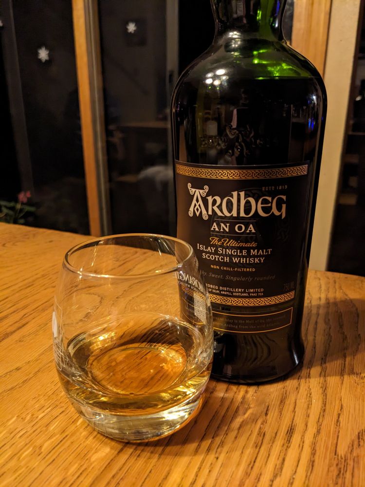 Dram of scotch in front of a bottle of An Oa from the Ardbeg distillery 