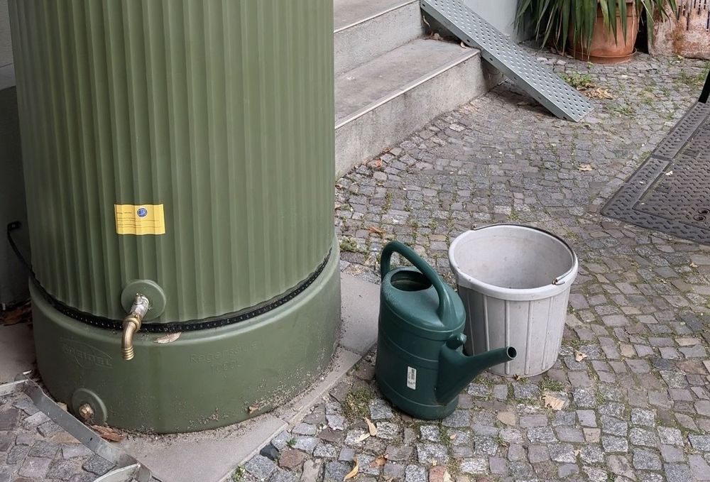 Foto von einer Regentonne auf einem Fußweg.