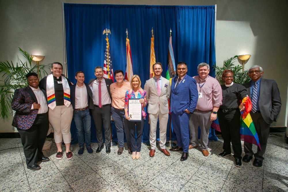mayor deegan and 10 other people holding the official proclamation for pride month in jacksonville