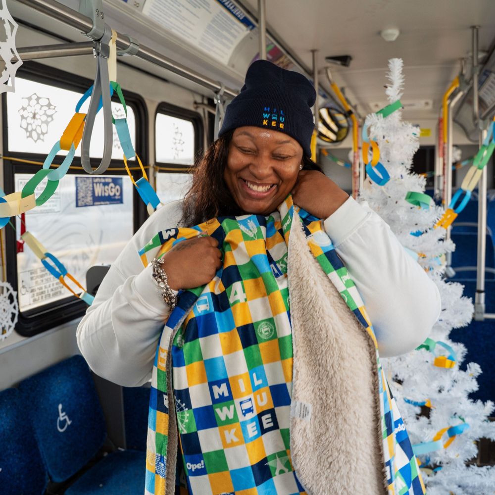 Woman on decorated MCTS bus with MCTS winter swag