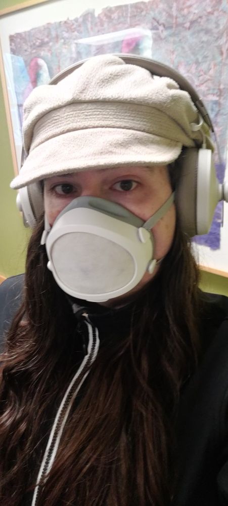 joyces wearing her favorite hat, big over ear headphones, and a flomask