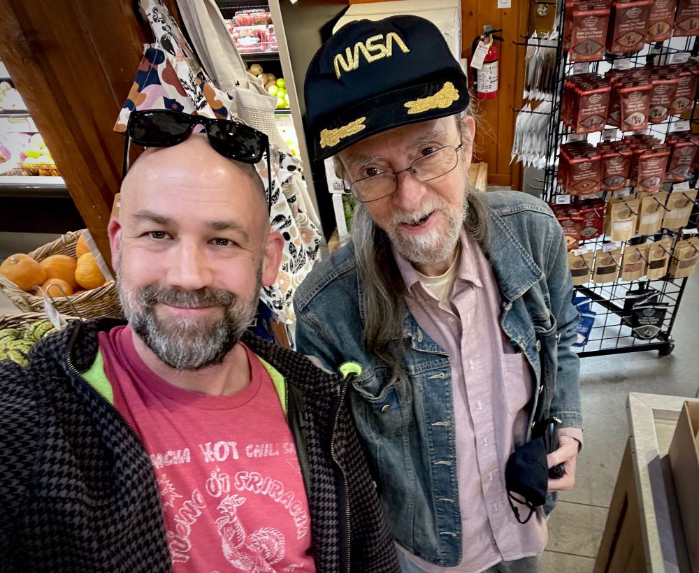 Photo of Michael Blackbourn and spider Robinson. Robinson is wearing a nasa ball cap