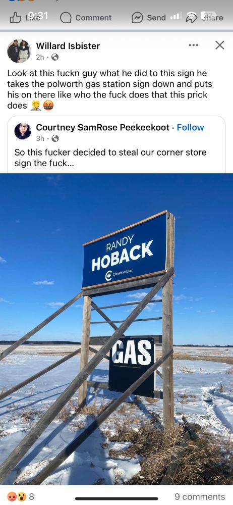 A wooden gas sign that has been covered over with a blue Conservative sign that says Randy Hoback. Under the sign is a smaller black sign that says GAS in white.