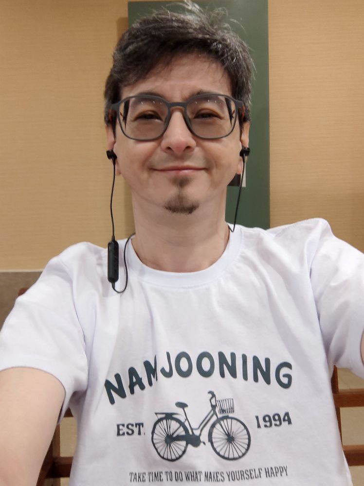 Homem asiático, cabelos escuros com fios grisalhos, usando um óculos quadrado e fones de ouvido auriculares pretos. Usa uma camiseta branca onde pode-se ler "NAMJOONING"
Abaixo, o desenho de uma bicicleta. Do lado esquerdo da Bicicleta aparece a palavra EST e do lado direito da bicicleta, 1994, ano de nascimento de Kim Namjoon, RM do BTS.
Abaixo de tudo a frase "Take the time to do what makes yourself happy"