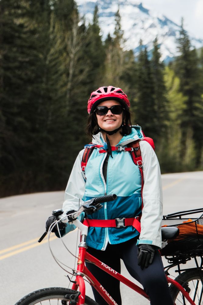 Bike rider posing for a picture with mountains in the background