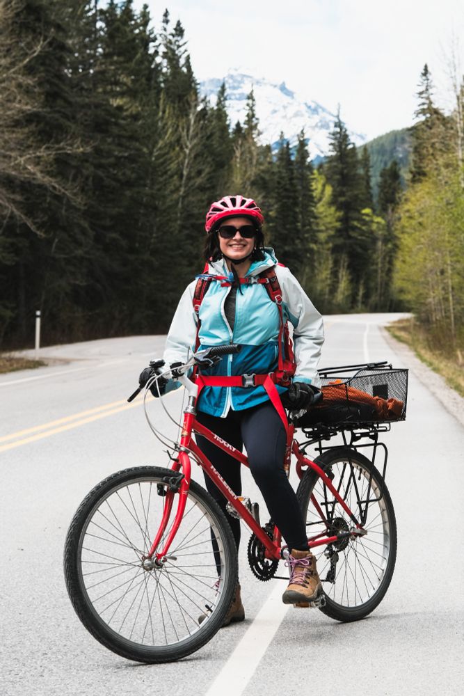 Bike rider posing for a picture with mountains in the background