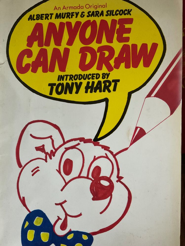 A book cover features a cartoon bear with a bow tie. The name of the book, which is called Anyone Can Draw, is featured in a speech bubble, along with the name of the authors, Albert Murfy and Sara Silcock. Text on the cover reads “Introduced by Tony Hart”.