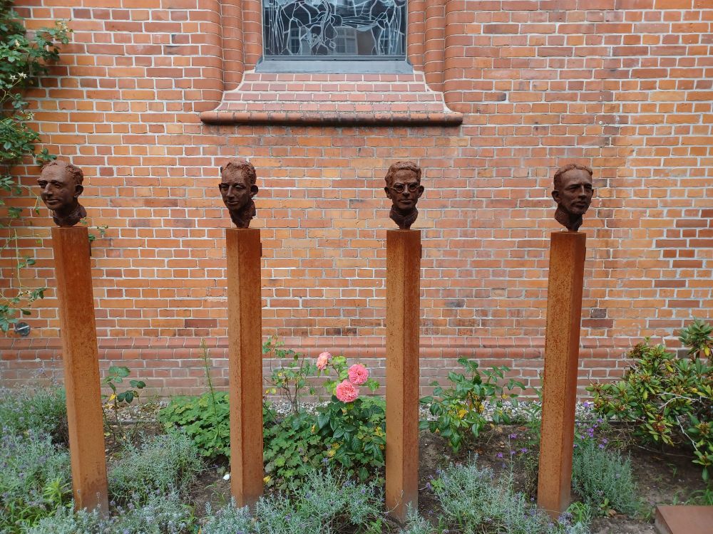 Die vier Stelen mit Köpfen der vier Lübecker Märtyrer Prassek, Eduard Müller, Hermann Lange und Karl Friedrich Stellbrink vor dem St. Marien-Dom in Hamburg 
