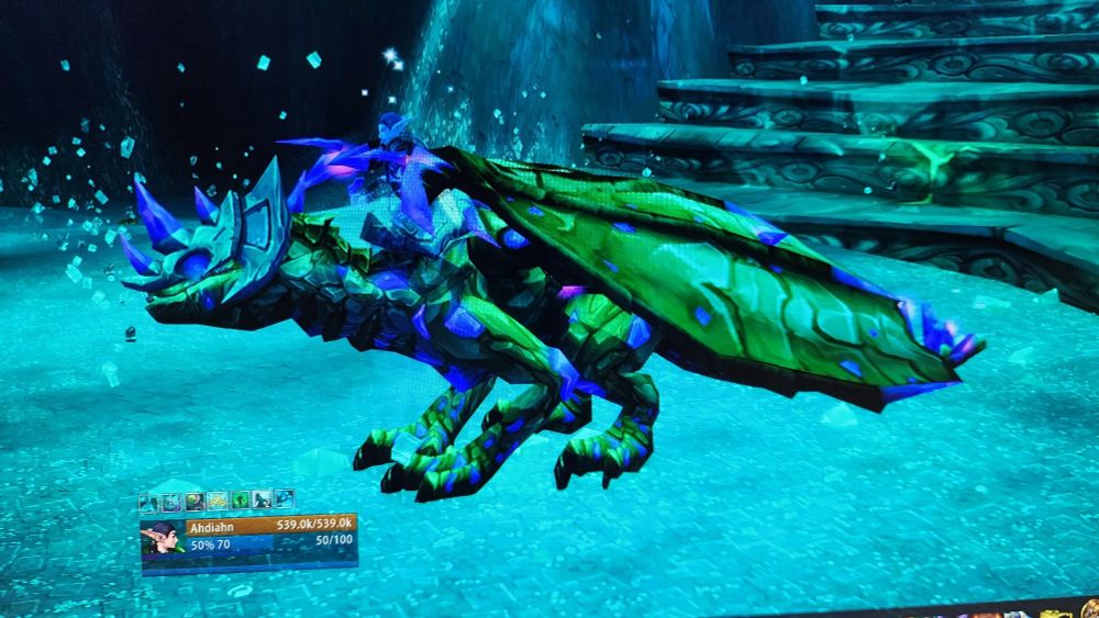 A photo of a computer screen, on which is a dragon mount inside the world of Warcraft game. This is the phosphorescent stone Drake, And it drops from a rare spawn of a rare rarespawn.