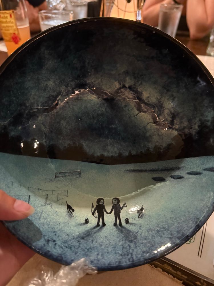 A bowl with a galaxy sky and four dogs (2 booplefloofs and 2 Chesapeake bay retrievers) and two astronauts holding hand 