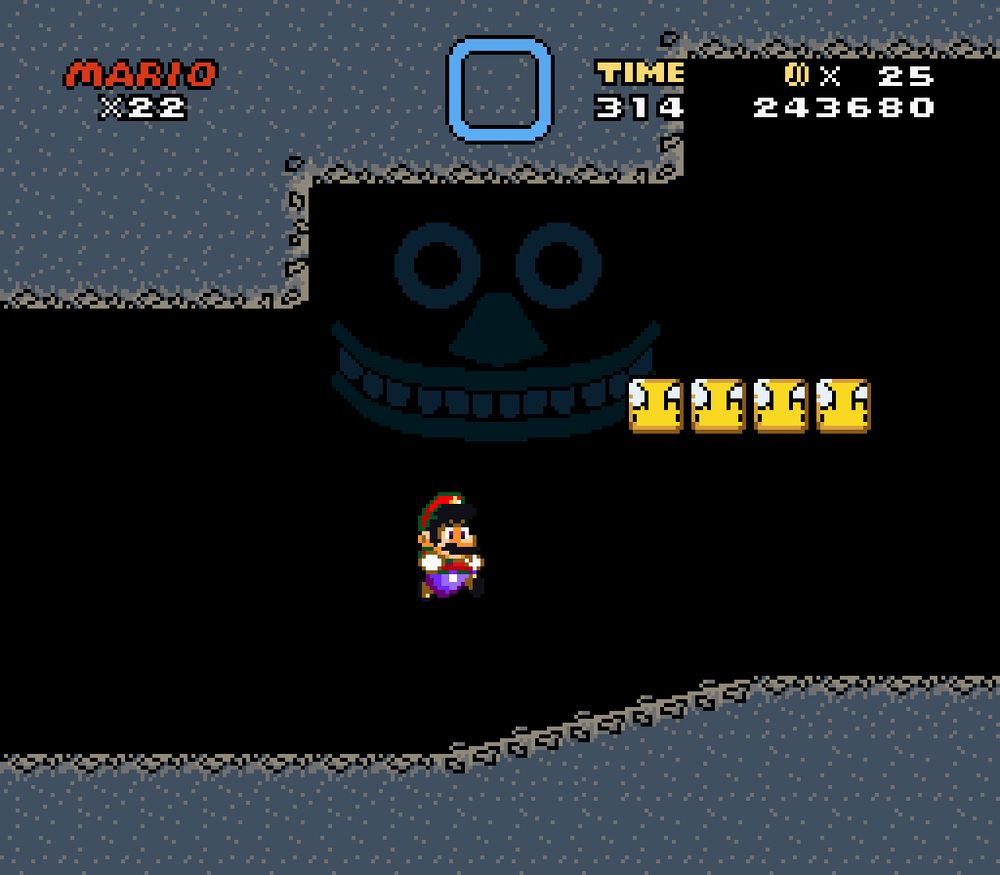 A dark underground cave, inside a mountain, the face of which stares at Mario.