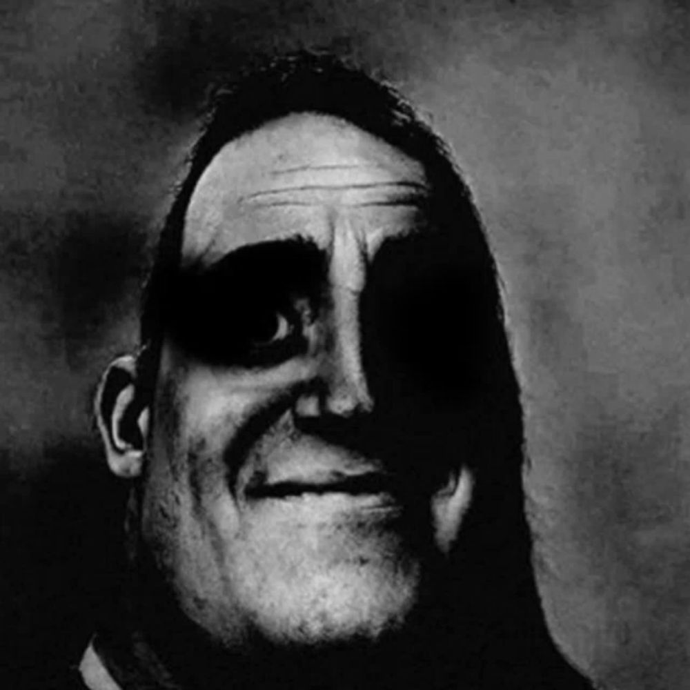 a black and white photo of a man 's face with a shadow on it .