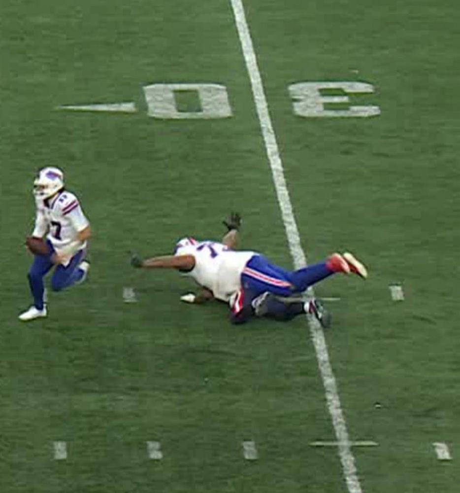 Josh Allen running with the football as Dion Dawkins holds both of his hands in the air while pancaking a Pats defender to try to show he wasn't holding. 