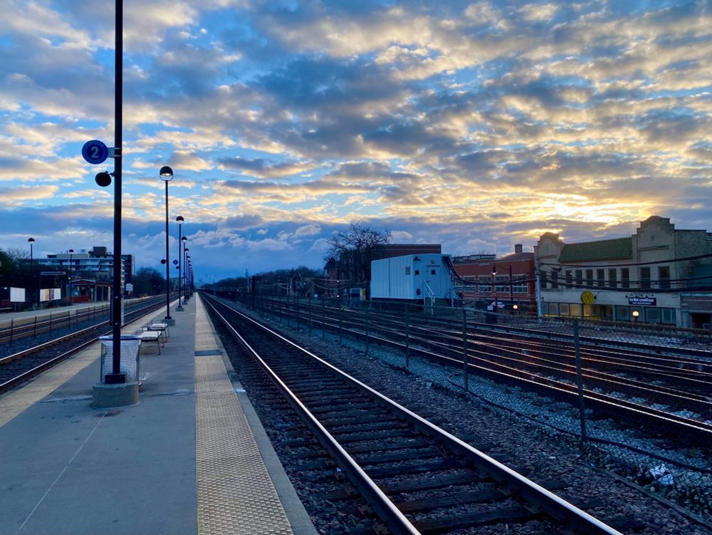 Sunrise from the right over tracks at the train station