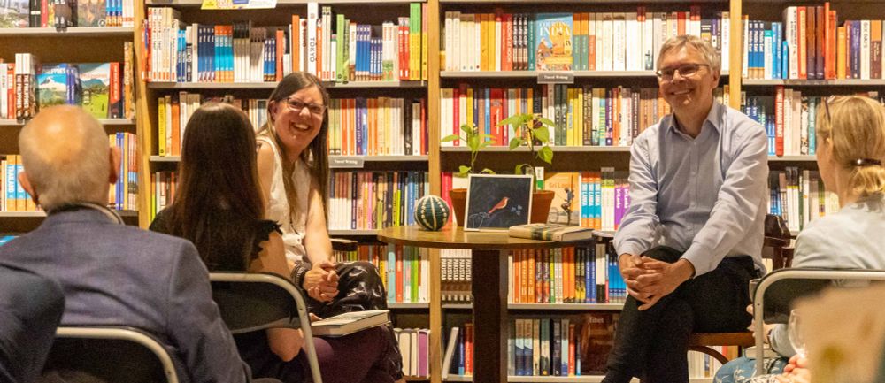 Two people looking at an audience in a bookshop.