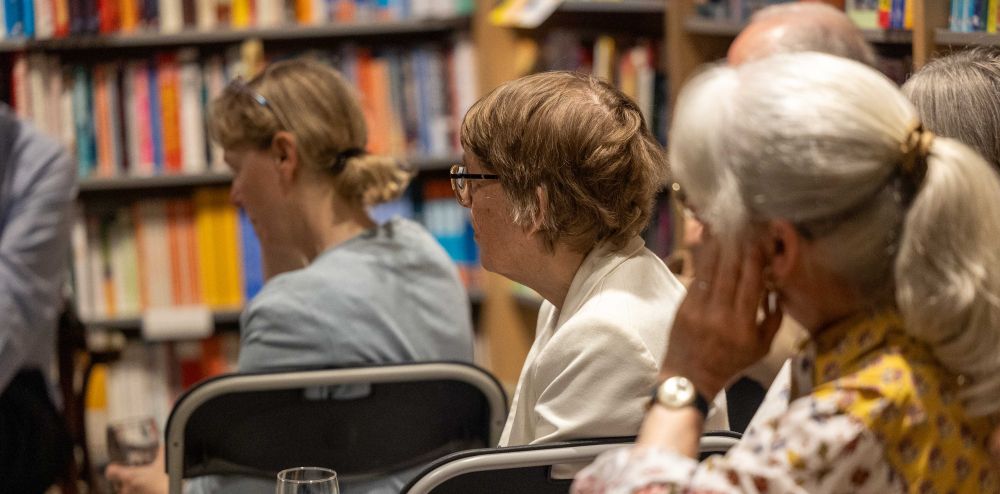 Three woman sitting on chairs looking forwards.