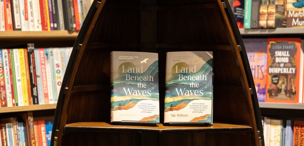 Two Land Beneath the Waves books on a shelf.