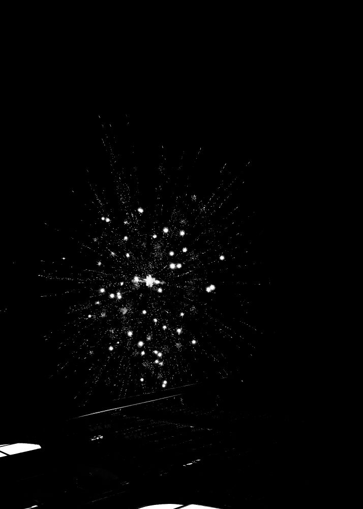 A burst of fireworks against a dark sky, with bright, star-like patterns radiating outward from a central point. Numerous small glowing trails extend in all directions, creating a layered, celebratory effect against the stark black background.
