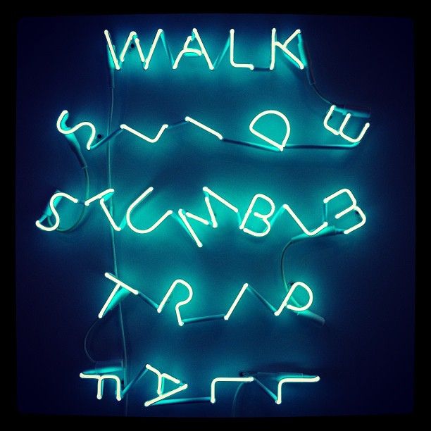 Blue neon reading, "WALK, SLIDE, STUMBLE, TRIP, FALL" at various angles to portray the action of each word.